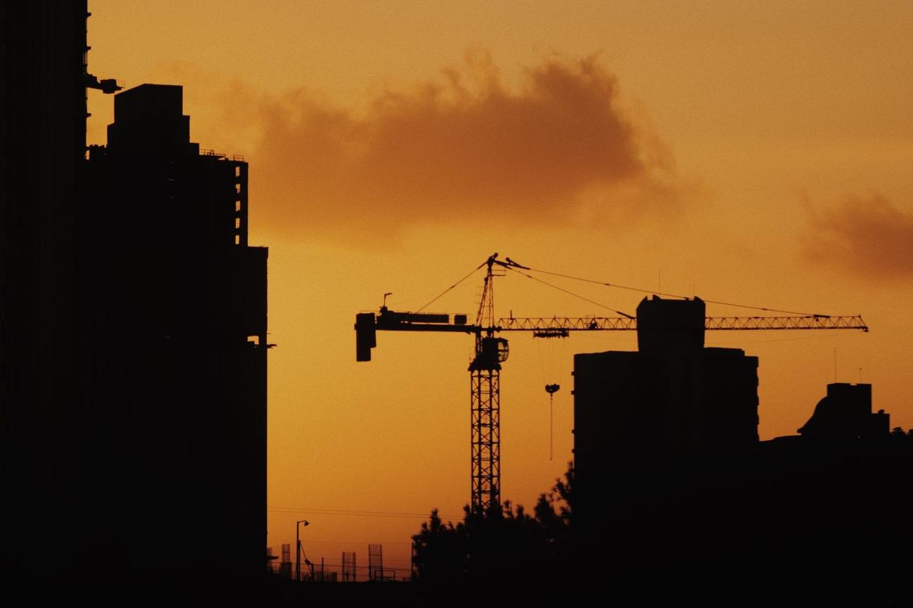 Skyline di cantiere con gru al tramonto
